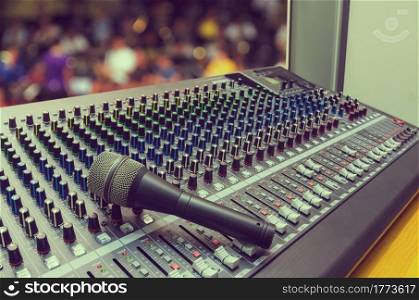 Microphone on mixer with blurred musical background, mixer music, mixer board. - style vintage.. Microphone on mixer board.