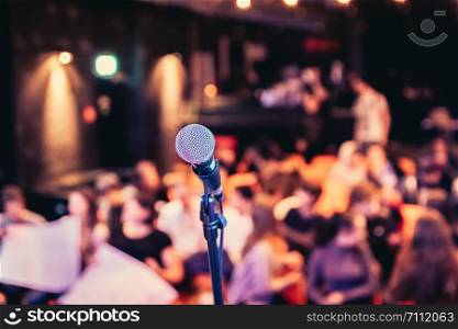 Microphone stand in an event hall, audience in the blurry background