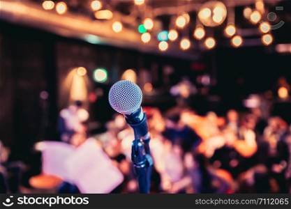 Microphone stand in an event hall, audience in the blurry background