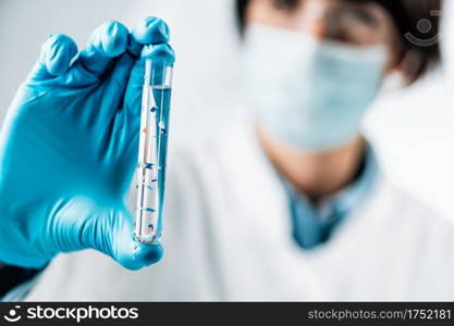 Microplastics concept. Scientist holding a test tube with water s&le full of microplastics or plastic particles. Microplastics in a test tube with water s&le