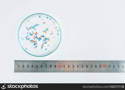 Microplastics in a Petri dish, environmental science concept . Microplastics in Petri Dish 