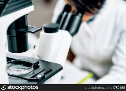 Microplastics Laboratory Research. Scientist using a microscope to analyze and quantify plastic particles in a water sample . Microplastics, Laboratory Research