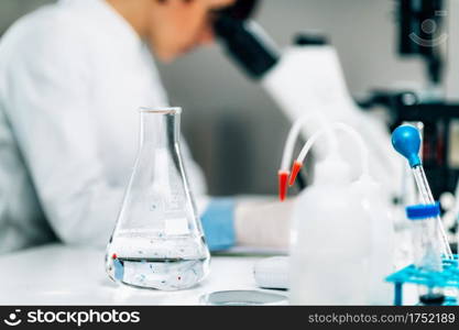 Microplastics Laboratory Research. Scientist using a microscope to analyze and quantify plastic particles in a water s&le . Microplastics, Laboratory Research