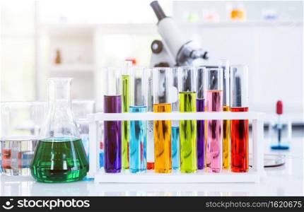 Microscope and test tubes with lab glassware in laboratory background, research and Scientific concept