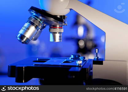 Microscope in a medical or scientific research laboratory with another one out of focus in the background.