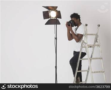 Mid adult (30-35 years) photographer in studio
