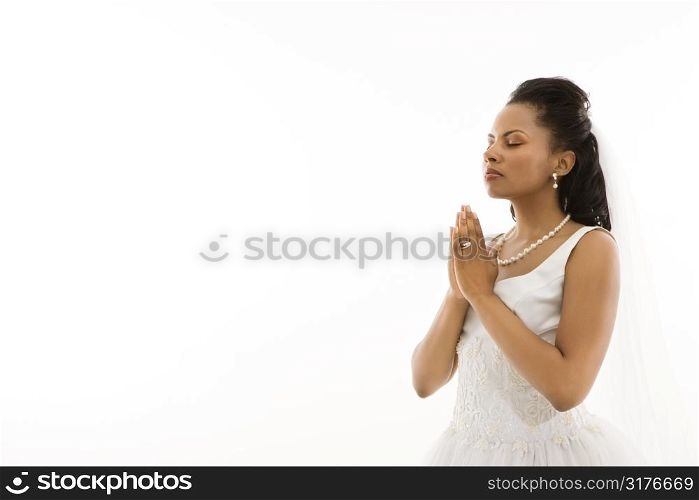 Mid-adult African-American bride praying with white background.