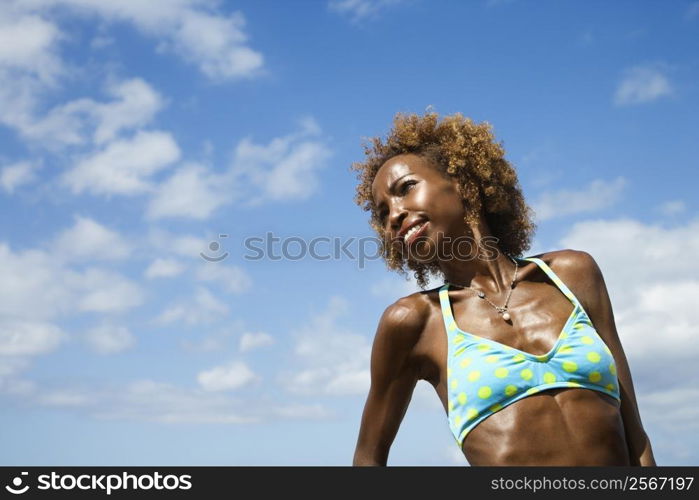 Mid-adult African American female smiling with blue sky in background.