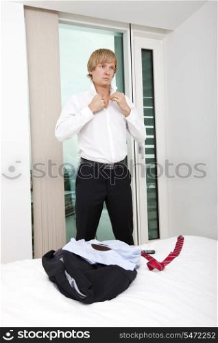 Mid adult businessman getting ready in bedroom