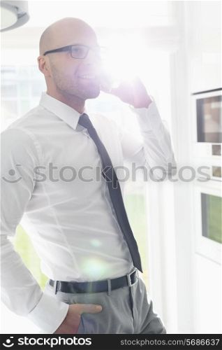 Mid adult businessman using smart phone at home