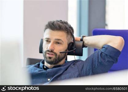 Mid adult businessman wearing telephone headset in office
