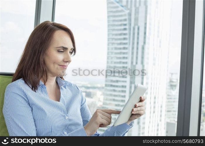 Mid-adult businesswoman using digital tablet in office