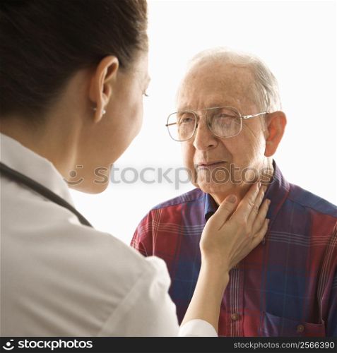 Mid-adult Caucasian female doctor checking an elderly Caucasian male&acute;s pulse.