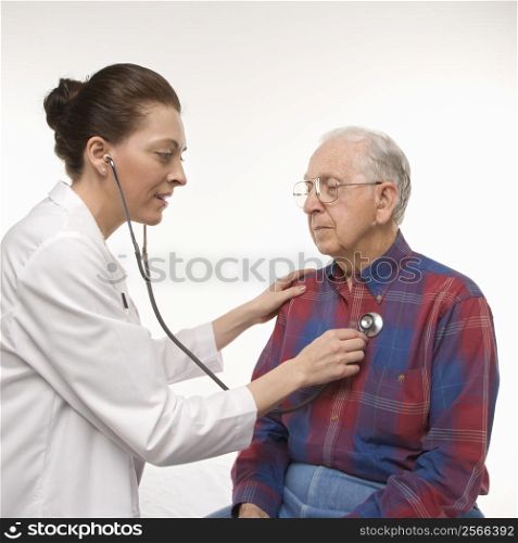 Mid-adult Caucasian female doctor listening to elderly Caucasian male&acute;s heartbeat with stethoscope.