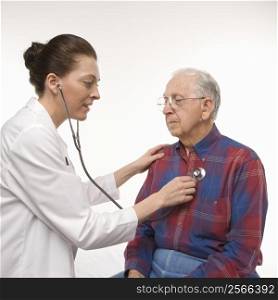 Mid-adult Caucasian female doctor listening to elderly Caucasian male&acute;s heartbeat with stethoscope.