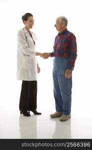 Mid-adult Caucasian female doctor shaking hands with an elderly Caucasian male.