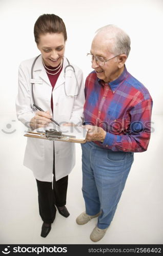 Mid-adult Caucasian female doctor showing papers to elderly Caucasian male.