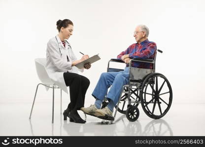 Mid-adult Caucasian female doctor taking notes with an elderly Caucasian male in wheelchair to her side.