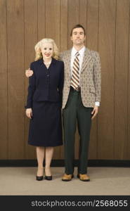 Mid-adult Caucasian male in retro suit with arm around mid-adult Caucasian female.