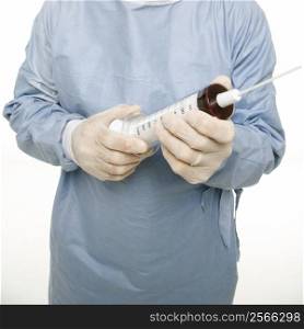 Mid-adult Caucasian male wearing scrubs and holding an oversized syringe.