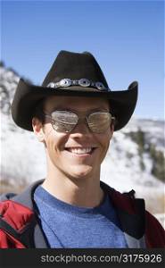 Mid-adult Caucasian male wearing sunglasses and cowboy hat smiling at viewer.