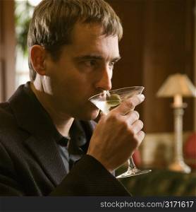 Mid adult Caucasian man drinking martini.