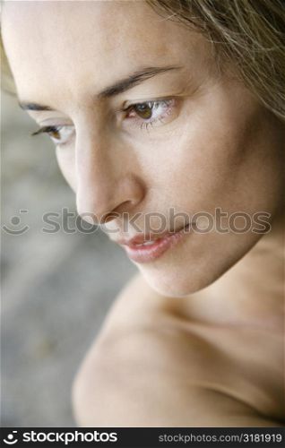 Mid adult Caucasian nude woman looking to side.