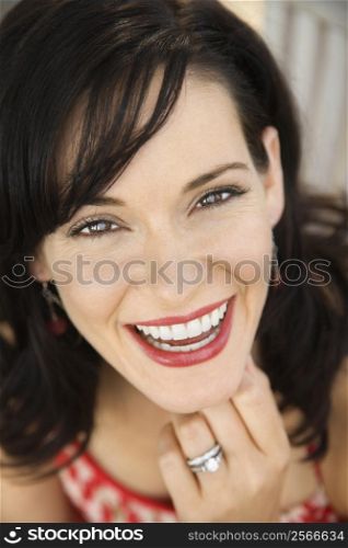 Mid-adult Caucasian woman smiling wearing wedding ring.