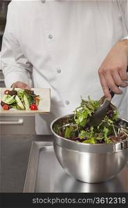 Mid- adult chef prepares leaf vegetables