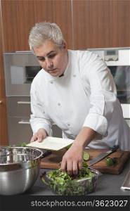 Mid- adult chef prepares salad
