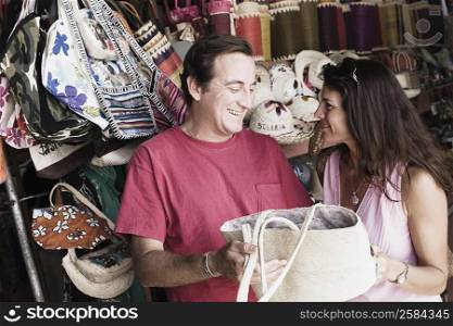 Mid adult couple holding a hand bag and smiling