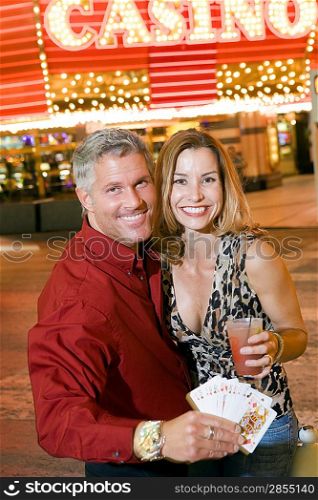 Mid-adult couple in front of casino building, portrait