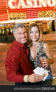 Mid-adult couple in front of casino building, portrait