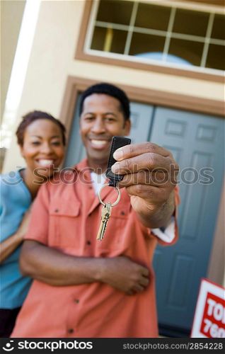 Mid adult couple in front of their new home