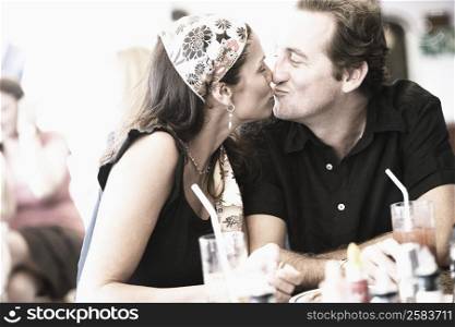 Mid adult couple kissing each other in a restaurant