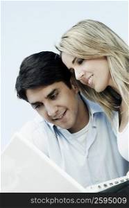 Mid adult couple looking at a laptop and smiling