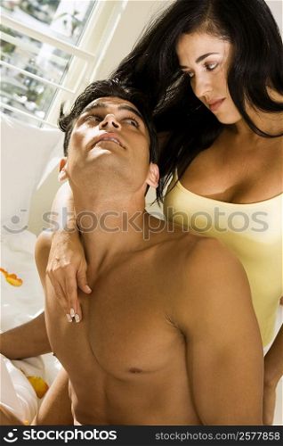 Mid adult couple looking at each other on the bed