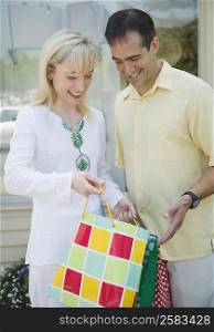 Mid adult couple looking into a shopping bag and smiling