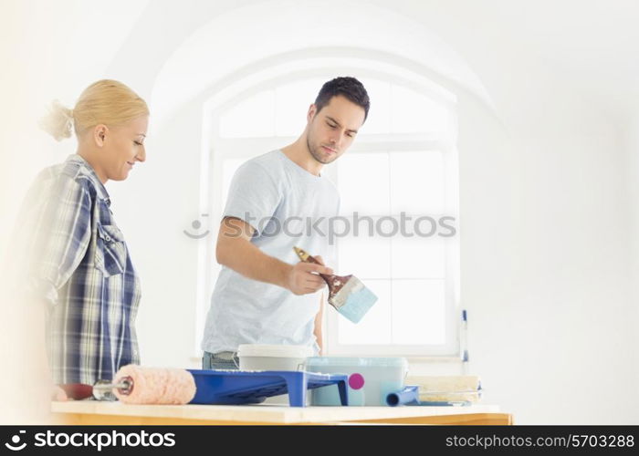 Mid-adult couple painting in new house