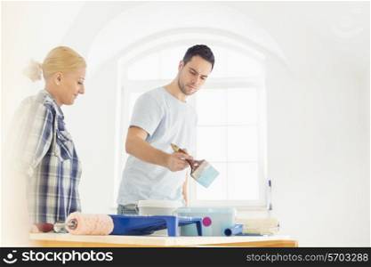 Mid-adult couple painting in new house