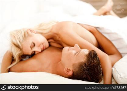 Mid adult couple relaxing as woman lies on top of her man