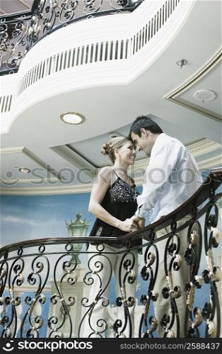 Mid adult couple romancing at a balcony of a ship