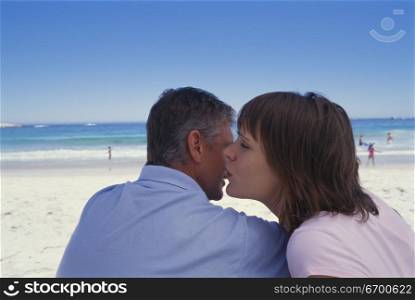 Mid adult couple sitting together on the beach
