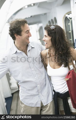 Mid adult couple standing with their arms around each other and laughing