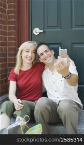Mid adult couple taking a picture of themselves and smiling