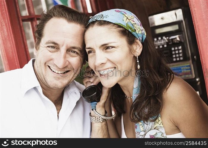 Mid adult couple talking on the telephone and smiling