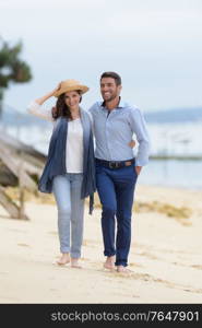 mid-adult couple walking on beach