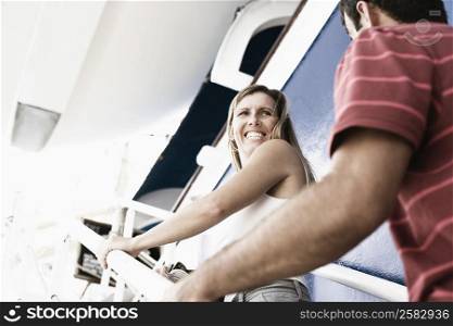 Mid adult couple walking up a staircase of a cruise ship and smiling