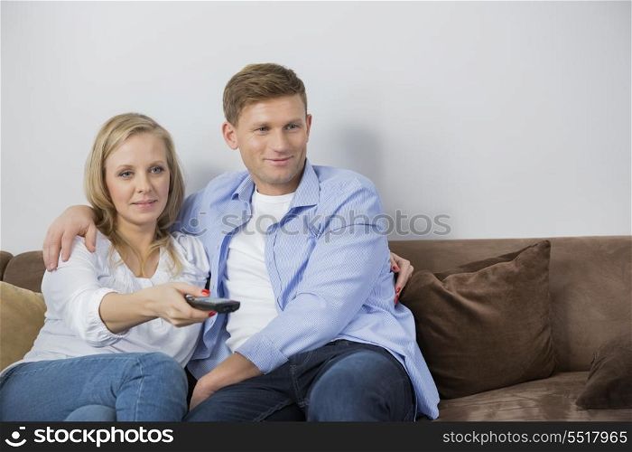 Mid adult couple watching television on sofa