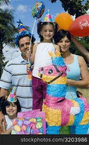 Mid adult couple with their daughters celebrating a birthday party